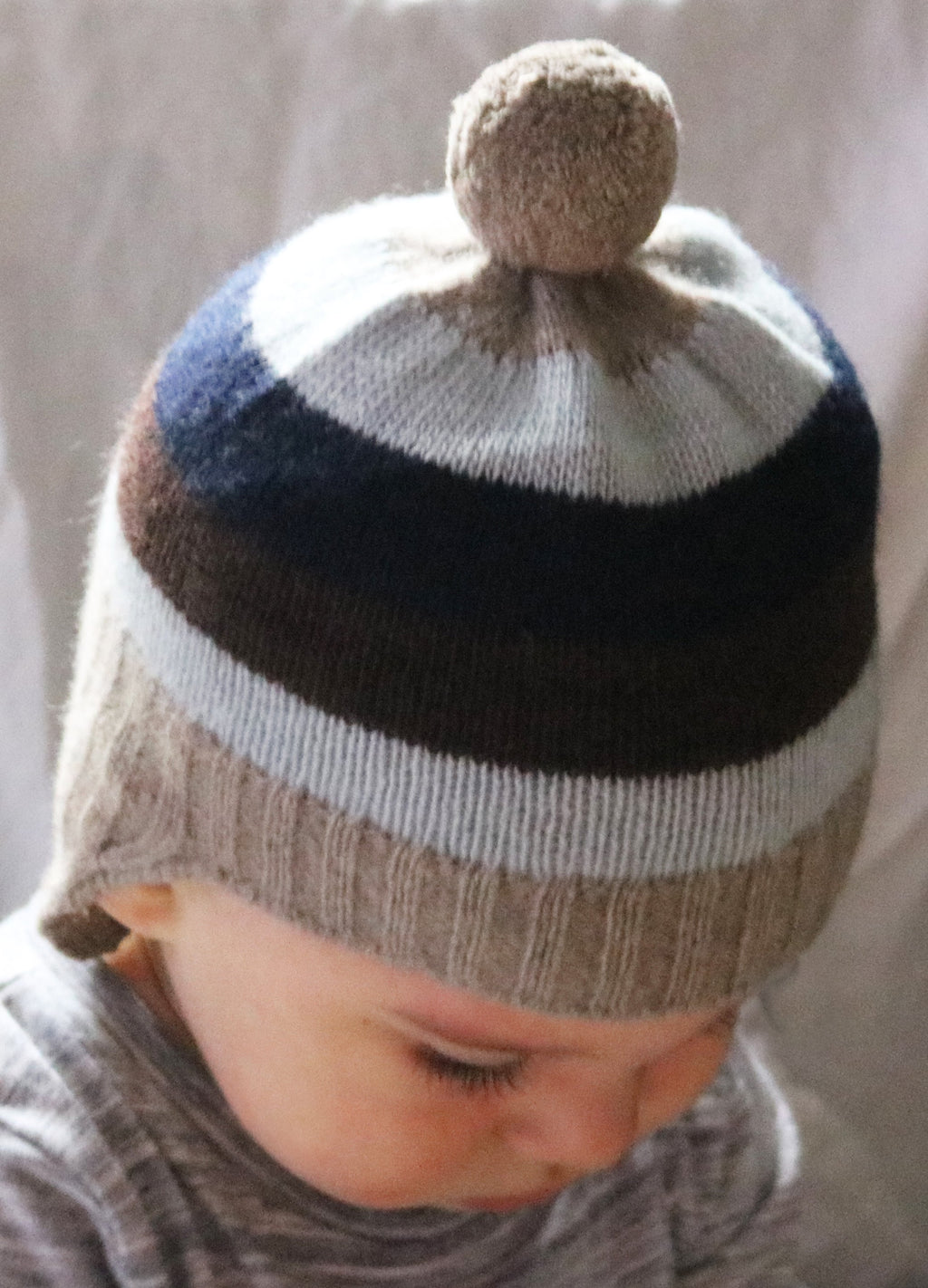 GORRO DE BEBÉ A RAYAS CON OREJERAS Y POMPÓN