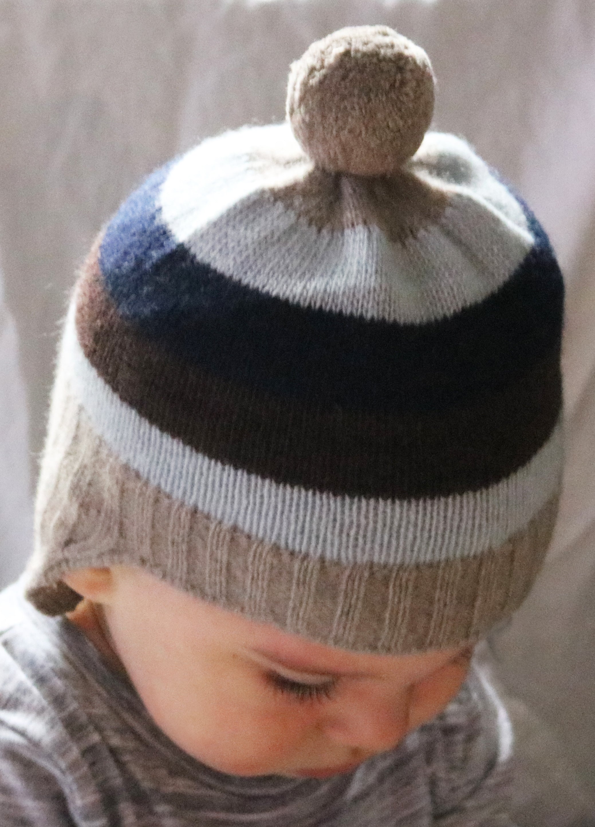 GORRO DE BEBÉ A RAYAS CON OREJERAS Y POMPÓN