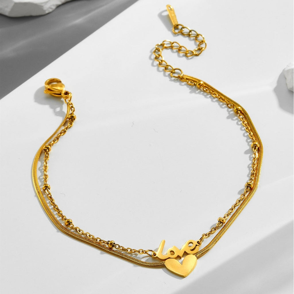 Tobillera de acero de titanio con letra inglesa de oro de 18k